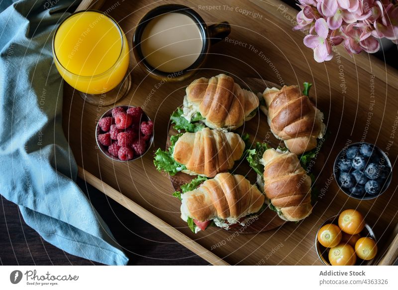 Appetizing French breakfast with croissant sandwiches on tray food juice coffee tasty serve table delicious fresh berry glass cappuccino yummy drink vegetable