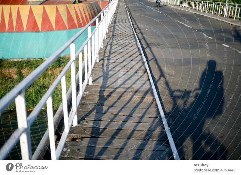 shadow of cyclist on the side of bridge bicycle man connection transportation cycling lifestyle one person health people riding bike outdoors road city day