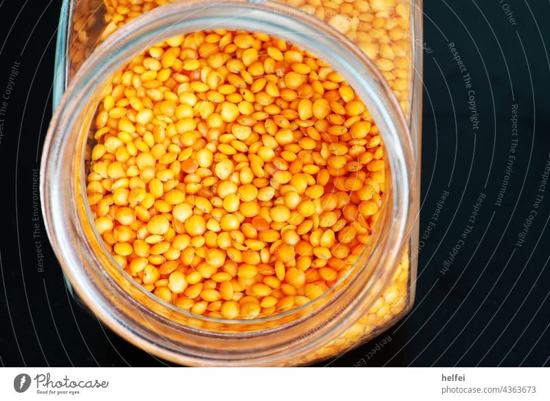 Red lentils in a jar as a stock in the kitchen with black background Lentils Glass Vegetarian diet Food Organic produce Studio shot Vegetable Healthy Diet