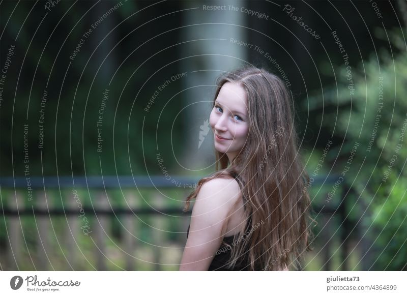 Portrait of smiling teen girl with long hair and flirty shoulder look Looking Girl Young woman 13 - 18 years 15-20 years old 16 16 years eye contact smilingly