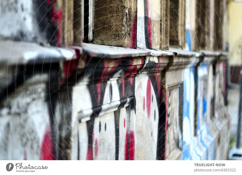 Age meets youth: artfully graffitied dilapidated facade on the ground floor of an old house in Babelsberg, seen from the side at an acute angle. Facade