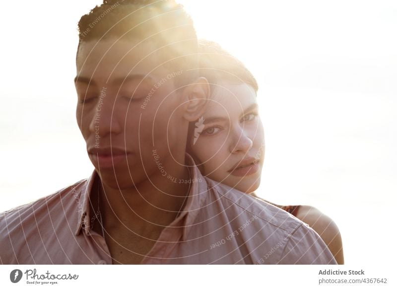 Tender multiethnic couple embracing on beach embrace love from behind seashore tender serene hug relationship multiracial diverse black african american