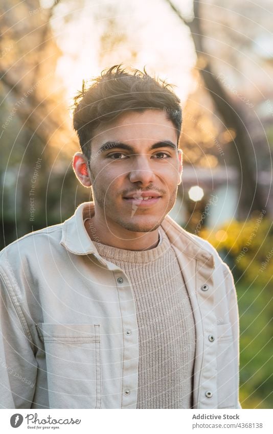 Happy man on sunny day in park handsome smile sunlight cheerful charismatic appearance happy glad male joy weekend optimist delight style enjoy carefree