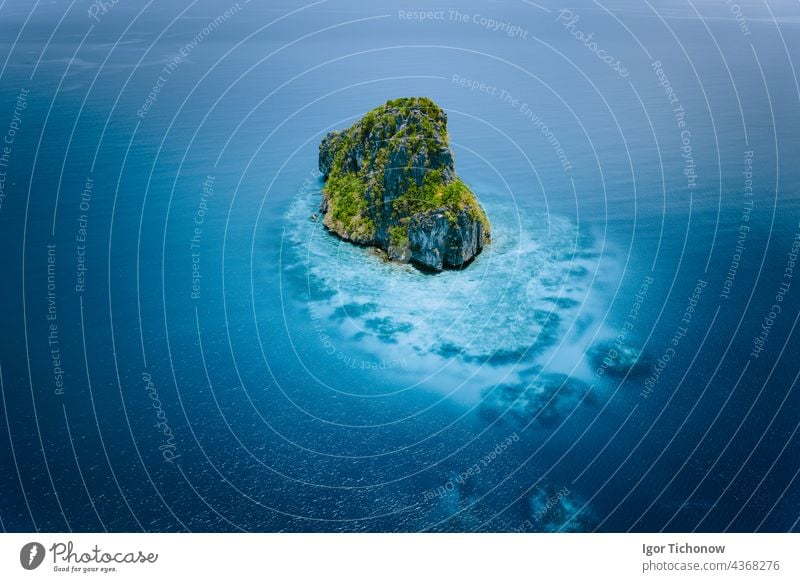 Drone shot of a beautiful remote rocky island surrounded by turquoise blue water. The Bacuit Archipelago is one of the best places to dive. El Nido, Palawan