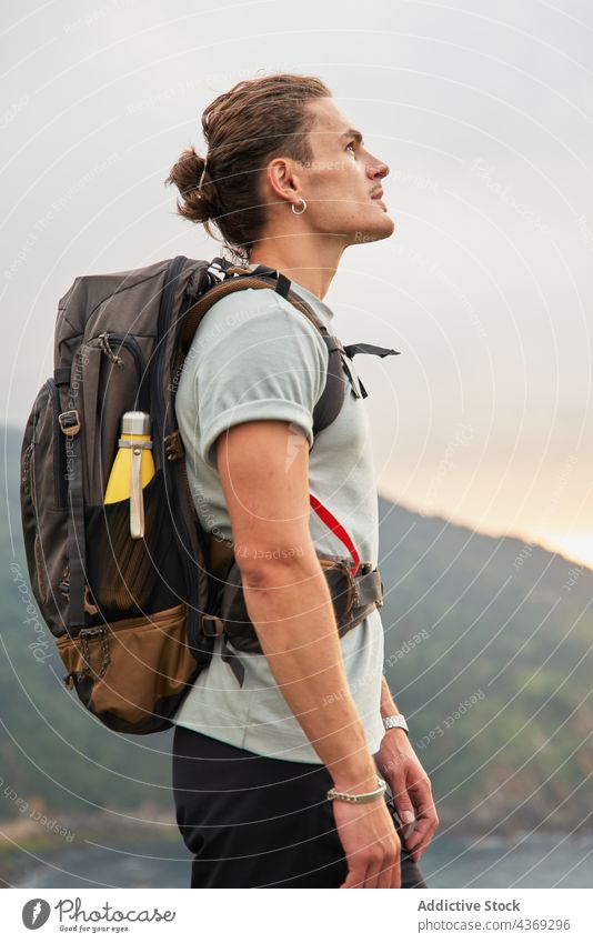 Male hiker standing on rock above sea man viewpoint admire travel trekking summer adventure male trip nature observe edge traveler journey enjoy rocky majestic