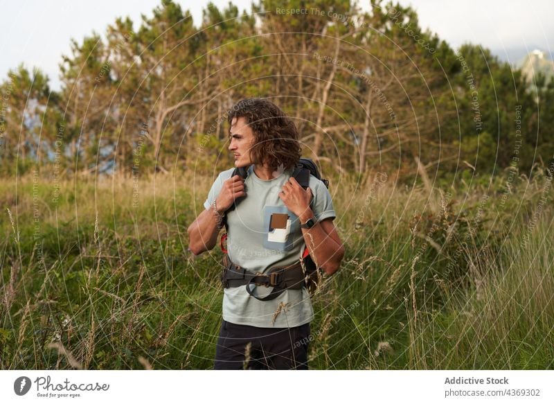 Traveling man walking in field at sunset travel backpacker summer trekking traveler evening freedom male meadow sundown nature adventure countryside vacation