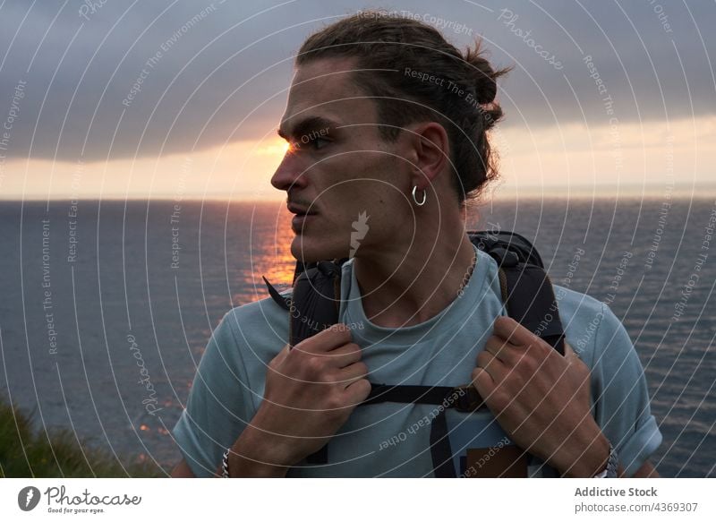 Male hiker standing on rock above sea man viewpoint admire travel trekking summer adventure male trip nature observe edge traveler journey enjoy rocky majestic