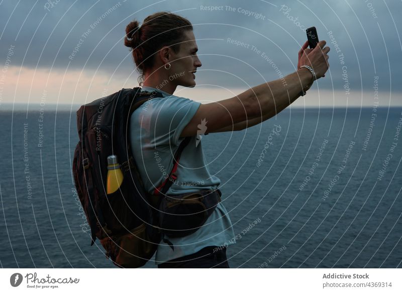 Traveler taking photo of sky over sea man take photo smartphone traveler sundown twilight male device summer mobile moment vacation gadget seascape photography