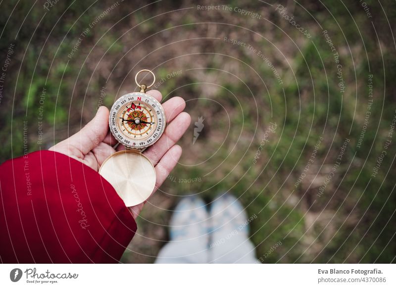 unrecognizable woman holding compass in forest. top view. Hiking and nature caucasian hiking backpacker navigation orienteering leisure guide searching hiker