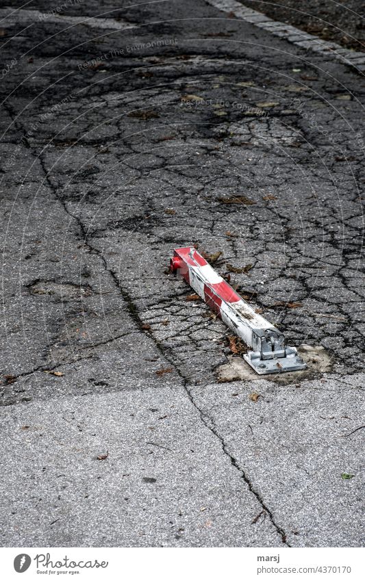 Parking lockout, overridden. Asphalt brittle Old corrupted Parking lot off Loneliness Street Red-white-red