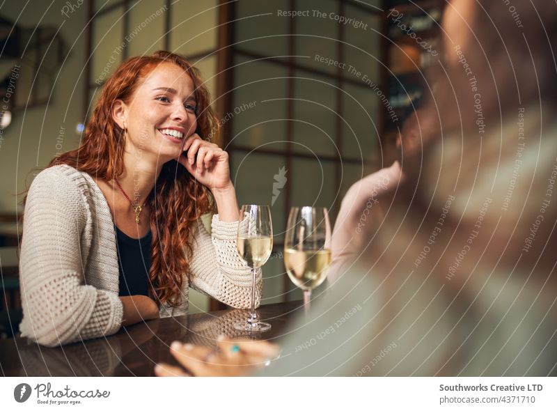 Young woman relaxing with friends in bar young relaxation drink hospitality smiling happy redhead indoors day venue interior two pair caucasian people candid