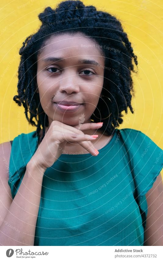 Portrait of young woman with Afro hairdo leaning against a wall african people happy portrait american model lady ethnicity afro laughing street curly trendy