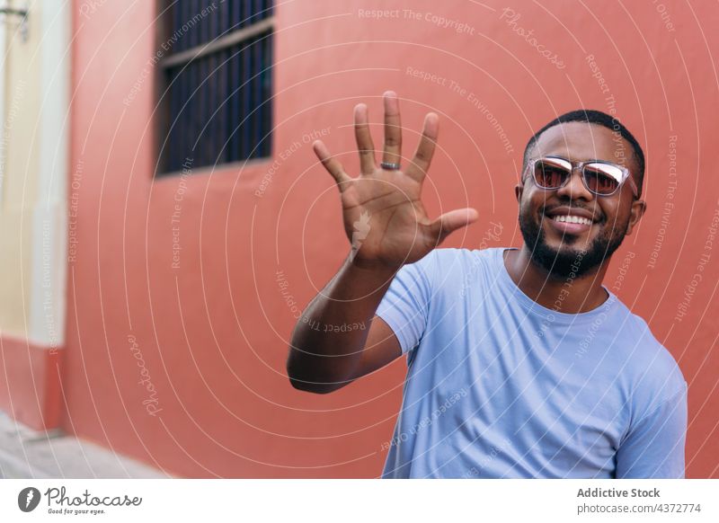 Smiling African man showing his hand while walking in the open air confident male adult african american black ethnicity photography people men cheerful