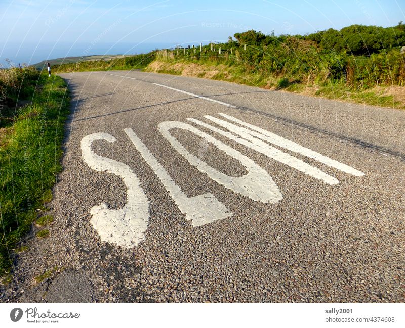 slowly down to the sea Street Country road England Great Britain coast Ocean Left-hand traffic Transport Asphalt Slowly Road marking Clue Traffic infrastructure