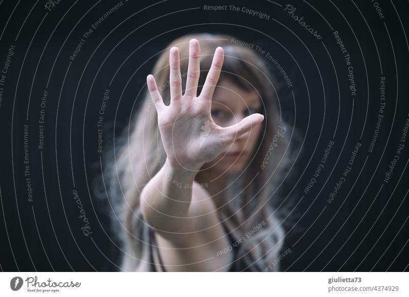 Portrait about violence against women | Young woman symbolizes: No - Stop - Halt , by stretching out her hand in front of her Looking into the camera