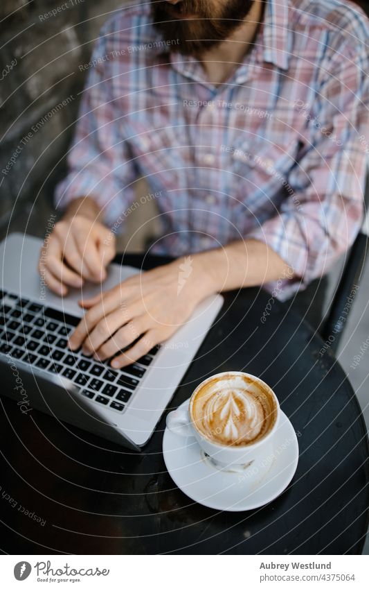 Young man  working on his laptop at an outdoor coffee shop 25-30 30-35 years adult american beard bearded blogger boss brunette business owner cafe california