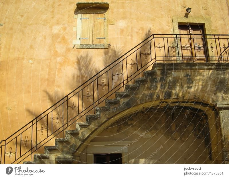 Silhouette of a palm tree on a monastery wall Stairs Architecture rail Banister Shadow Palm tree Monastery Facade Shutter door locked Sunlight Romance Moody