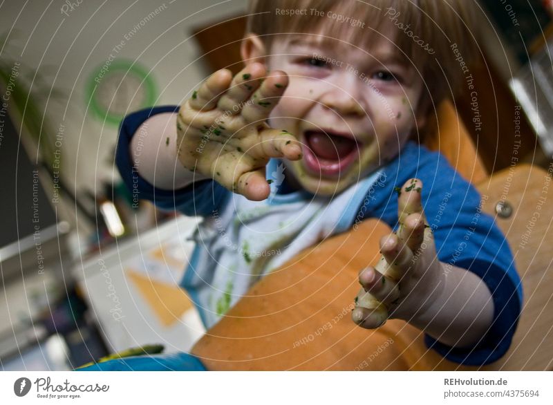 Child has spinach on her hands Looking into the camera Front view Upper body portrait 1 - 3 years Face Boy (child) Toddler Human being Healthy Eating Cute Green