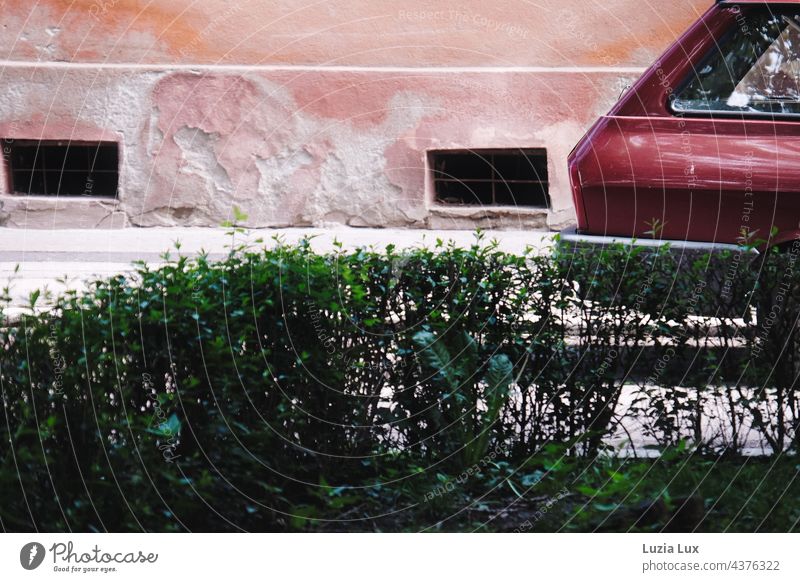 the rear of an old car in front of a crumbling house wall, color harmony in green and red Old Street House (Residential Structure) Facade Hedge Green Pink Red