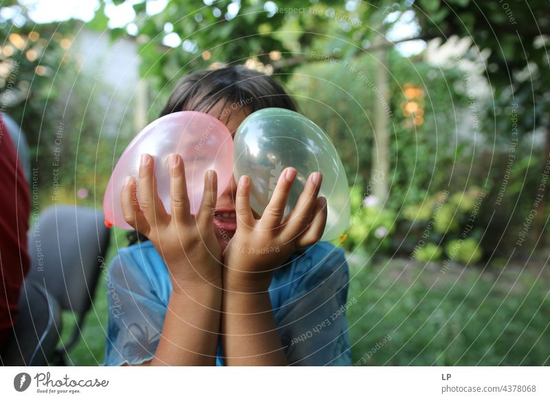 child having a great time playing with baloons pursuit of happiness pursuit - concept positive emotion Playful people multi colored baloons love - emotion