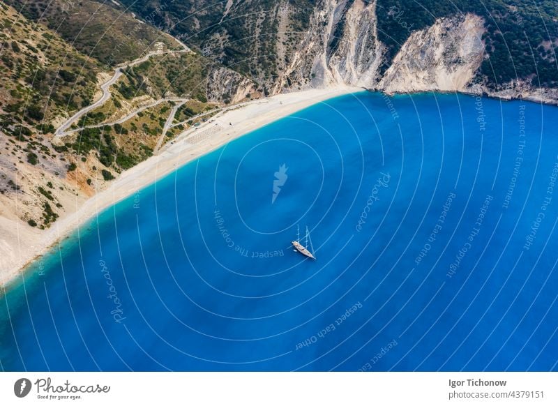 Aerial view of a luxury sailing yacht on the beach of Myrtos with blue bay on the island of Kefalonia, Greece myrtos Drone Beach Ocean Antenna Yacht Luxury