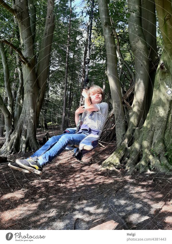 Child swinging on a tree swing in the forest Human being Schoolchild Forest Swing To swing Tree Beech wood Joy fun pleasure Light Shadow Sunlight Summer Nature