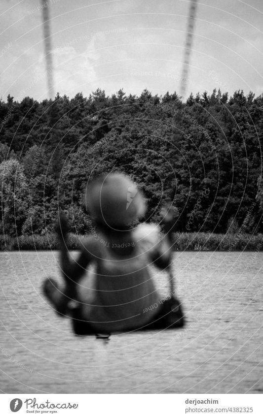 Come on the swing Luise. A girl is swinging overlooking the lake. You can't see her. There is a lot of forest in the background. To swing Exterior shot Day Joy