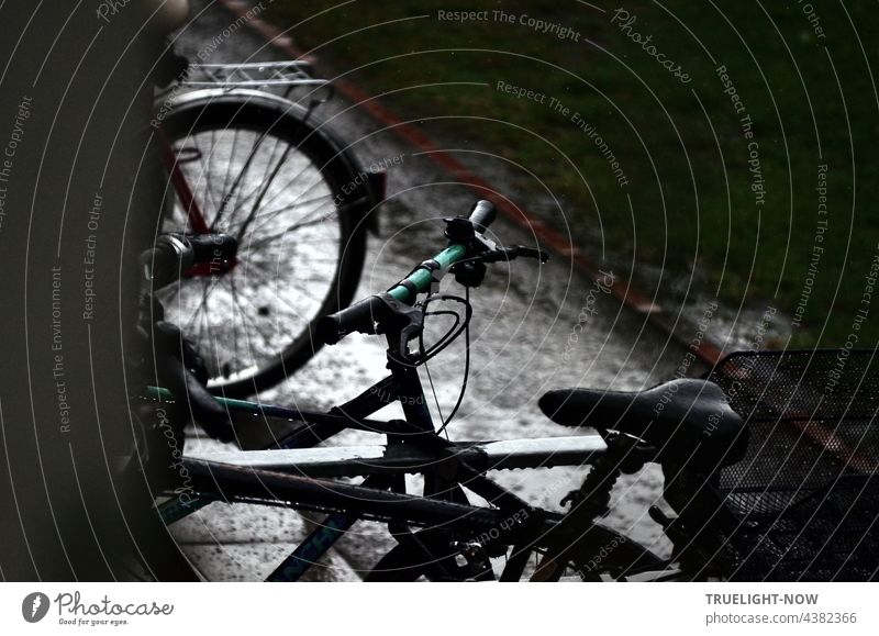 Dreary rainy day. Bicycles take a break. Gloomy, everything wet. bicycles partial view Saddle Handlebars rear wheel Rain heavy rain somber out turned off