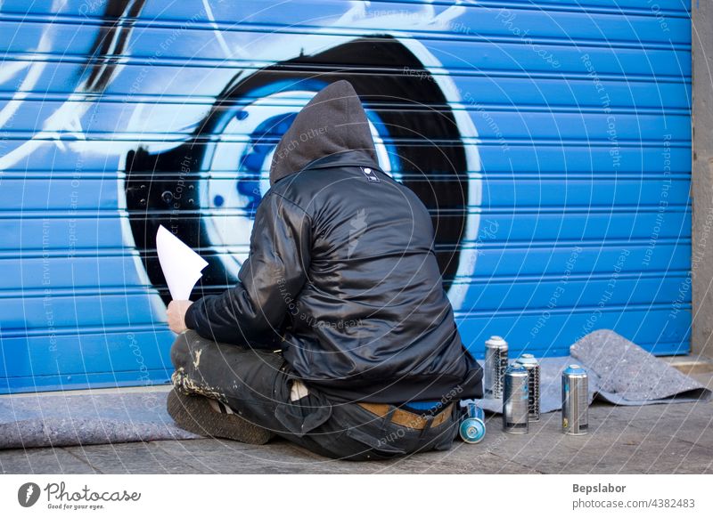 Artists painting a graffito Alternatively art artist blue b-boy band aerosol spray hood city color culture young youth graffiti hip-hop illegal lifestyle male