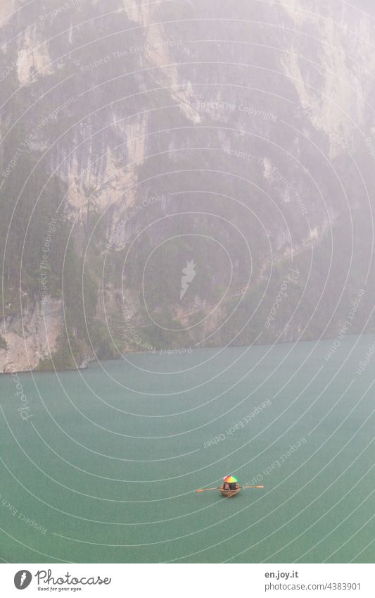 Boat trip in the rain on the Braies Lake Prags Wildsee Dolomites mountain lake Rain boat Rowboat Umbrella Rock Steep Vacation & Travel Tourism Trip South Tyrol