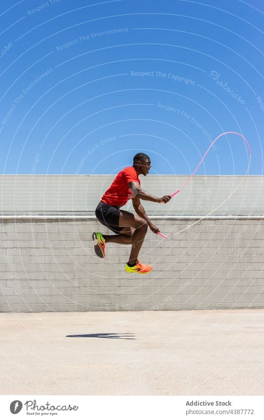 Fit black sportsman jumping rope during workout moment cardio exercise active energy athlete training male ethnic african american fitness skip leap activity