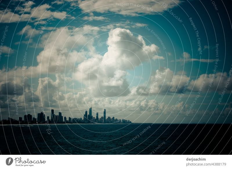 Mysterious cloud formations in the blue sky.  Many skyscrapers as a backdrop against the dark water. Architecture Town Sky Downtown Building High-rise