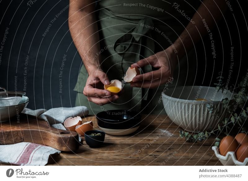 Crop man breaking egg for pastry cook bowl table kitchenware raw rustic male chef lumber add fresh cuisine prepare ingredient organic guy domestic tradition