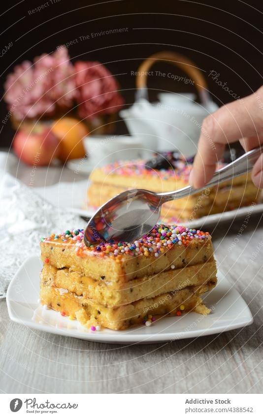 Crop person eating delicious cake served on table turron de dona pepa dessert treat nougat sweet dragee decoration garnish tasty food tradition cuisine wooden