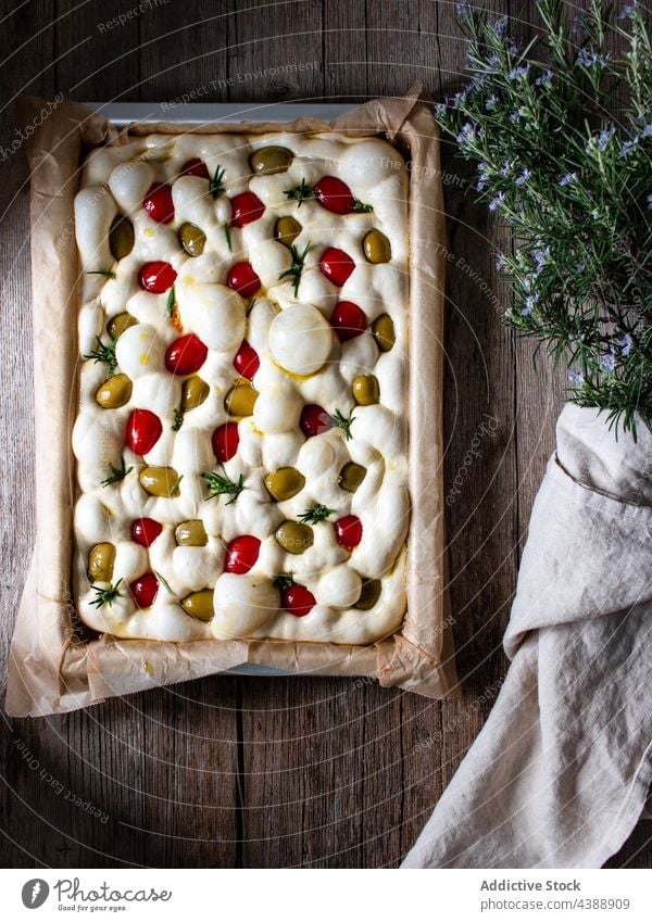 Delicious focaccia with sun dried tomatoes garnish cook prepare raw dough process bread tradition baking paper dish homemade kitchen food table bakery cuisine