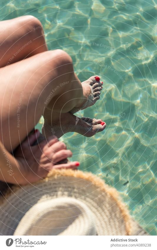 Crop woman sitting on pier near sea in summer paradise vacation sunny holiday enjoy quay female playa de muro alcudia mallorca spain relax rest water aqua