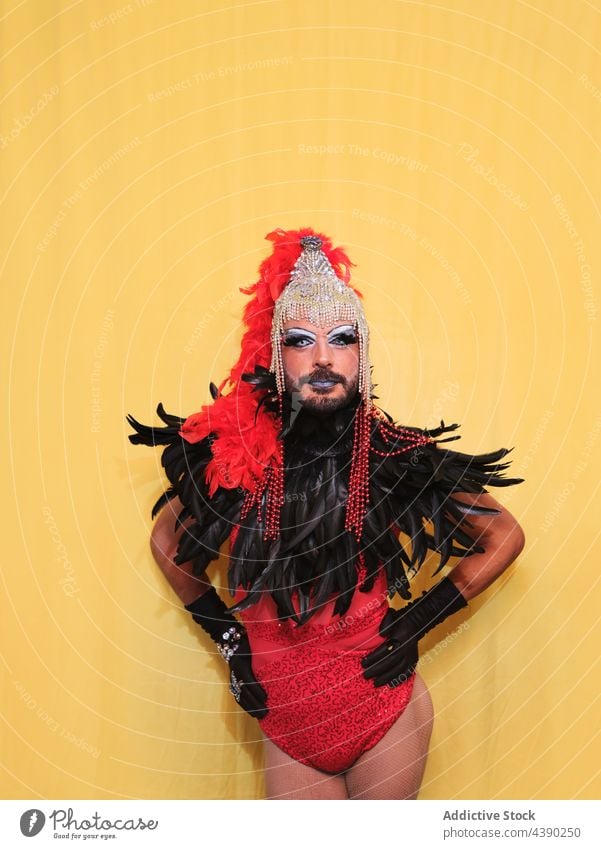 Drag queen model in bright costume man drag queen makeup outfit headdress wear gender feather transgender accessory headwear headgear feminine cloth extravagant