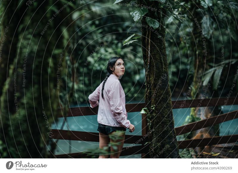 Travelling woman standing near river in jungle bridge traveler nature tropical adventure forest footbridge female young tourism vacation journey celeste