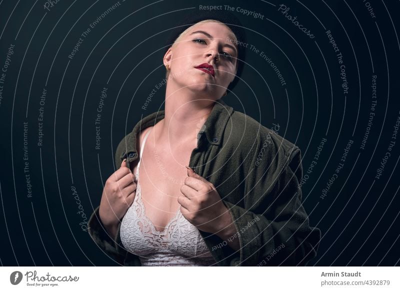 portrait of a young woman with a man's shirt, cap, and bustier studio confident heart love passion finger serious strong power powerful short hair business shy