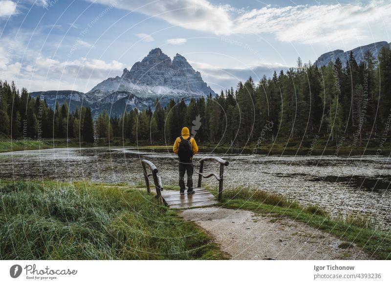 Man hiker with backpack enjoying Lago Antorno Lake,Tre Cime di Lavaredo mountain in background, Dolomites, Italy italy antorno lago lake dolomites alpine