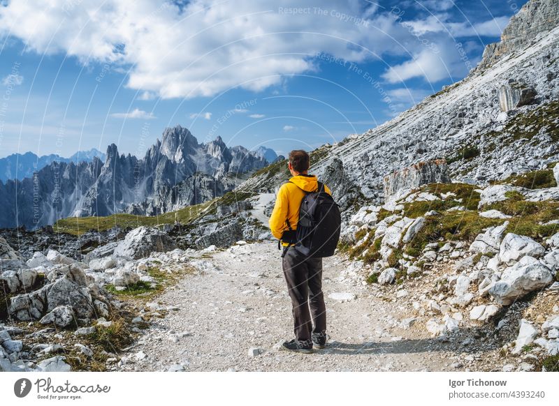 Man in yellow jacket hiking in Tre Cime National park. Cadini di Misurina in the background. Dolomites, Italy, Europe dolomites italy man cadini misurina