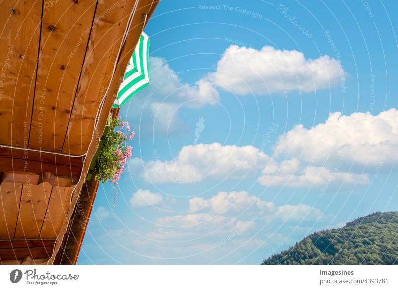 Balcony. Balcony with parasol and cloudy sky. Relaxing on a balcony in bloom in summer. Summer holidays vacation at home. relax at home. balconies Sunshade