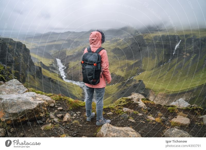 Close up of a woman with backpack enjoying icelandic highland and river fossa close to Haifoss waterfall in Iceland haifoss tourist travel landscape nature