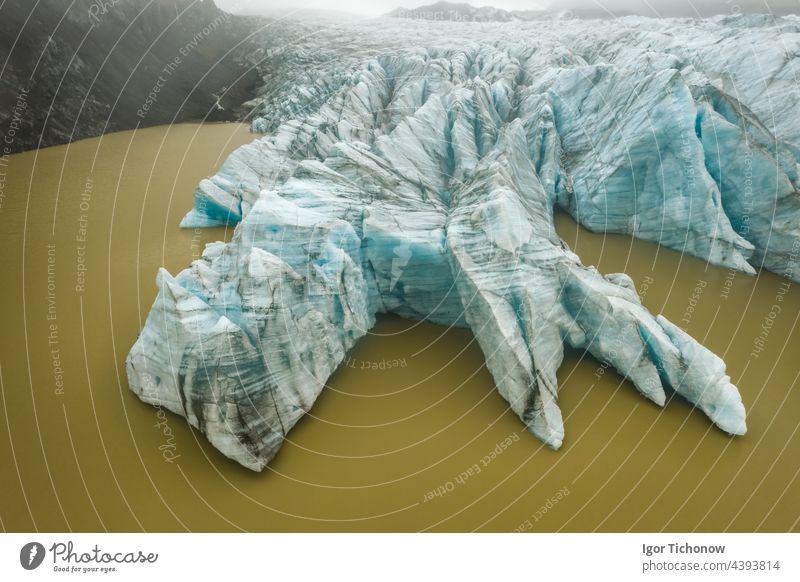 Aerial glacier blue colored tongue wall top down view and muddy glacial water lagoon in Fjallsarlon, Iceland iceland aerial fjallsarlon nature landscape iceberg