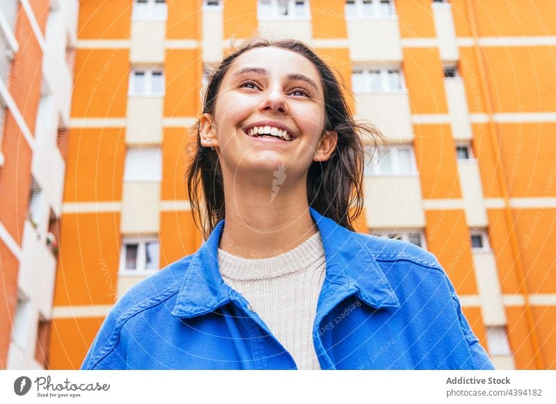 Happy woman standing in city and laughing bright color having fun urban cheerful street vivid female delight carefree style glad optimist happy excited content