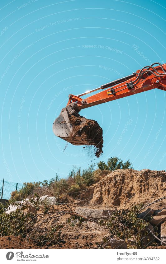 Closeup of a backhoe with dirt against sky Excavator shovel digging construction machinery heavy machinery construction site copy space working industry digger