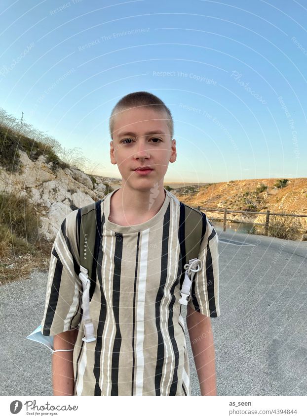 Boy on the street somewhere in the south Boy (child) Striped Sun sunset Backpack Street Looking into the camera Human being Colour photo Exterior shot portrait