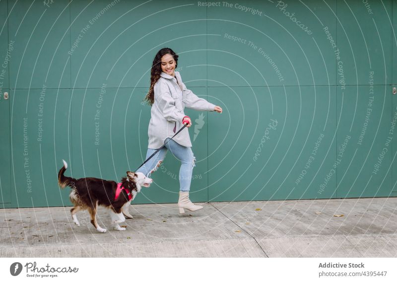 Woman running with dog along street woman having fun activity together border collie city stroll female pet animal canine owner leash companion friend puppy