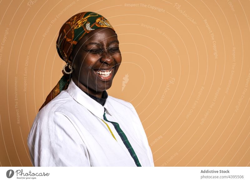 Laughing black woman in stylish headscarf in studio style laugh model cheerful trendy outfit fashion headgear female ethnic african american happy appearance