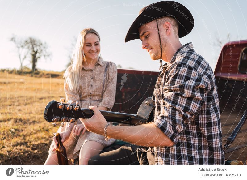 Couple with guitar sitting in vintage pickup truck car couple play countryside pick up retro music together cowboy romantic boyfriend vehicle relationship